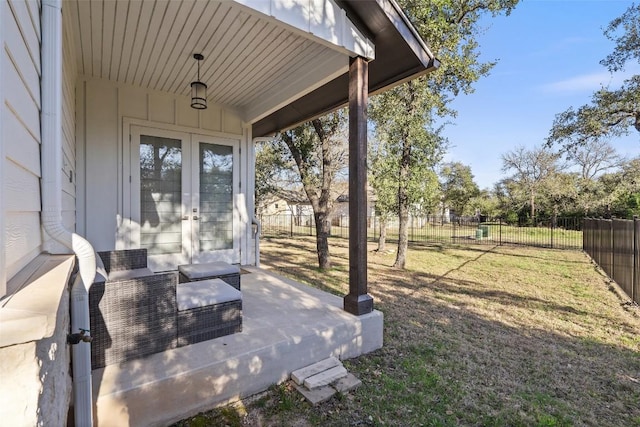 view of yard featuring fence and french doors