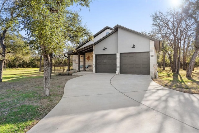 view of front facade with a garage, driveway, a front yard, and stucco siding