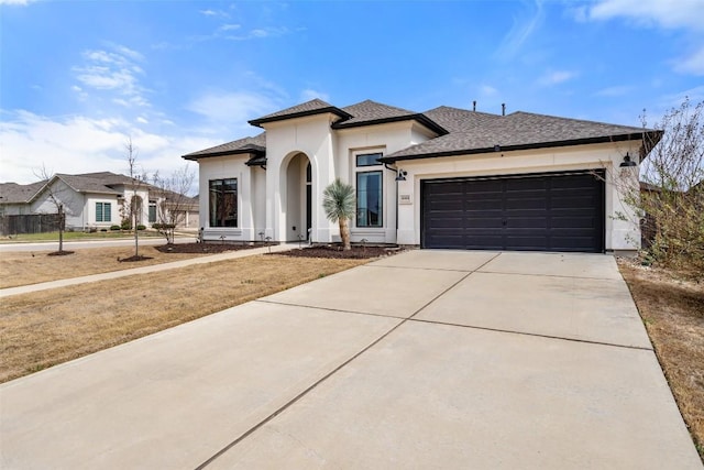 view of front facade featuring a garage, driveway, roof with shingles, and stucco siding