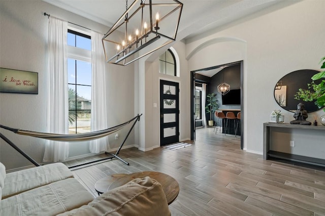 foyer entrance with a high ceiling, baseboards, and wood finished floors