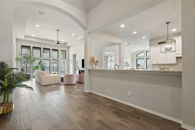 living area featuring recessed lighting, wood finish floors, visible vents, baseboards, and a ceiling fan