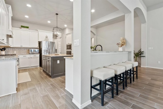 16801 Rakesh Way, Manor, TX 78653 - kitchen with light wood-type flooring, white cabinetry, appliances with stainless steel finishes, a center island, and recessed lighting