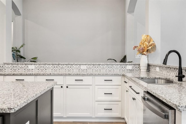 16801 Rakesh Way, Manor, TX 78653 - kitchen featuring stainless steel dishwasher, a sink, light stone countertops, and white cabinets