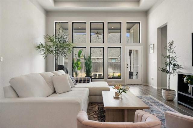 living room with a high ceiling, baseboards, and wood finished floors