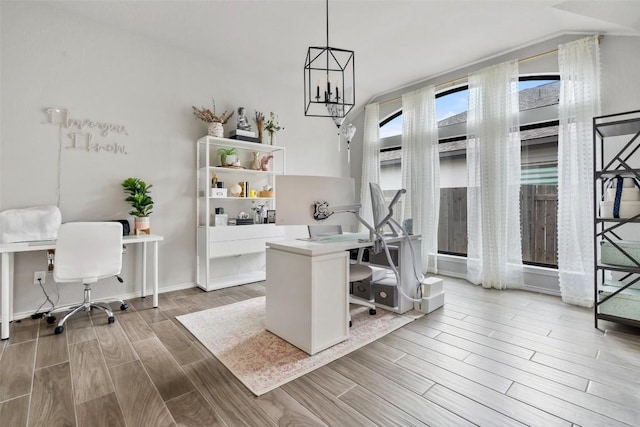 home office featuring lofted ceiling, wood tiled floor, a chandelier, and baseboards