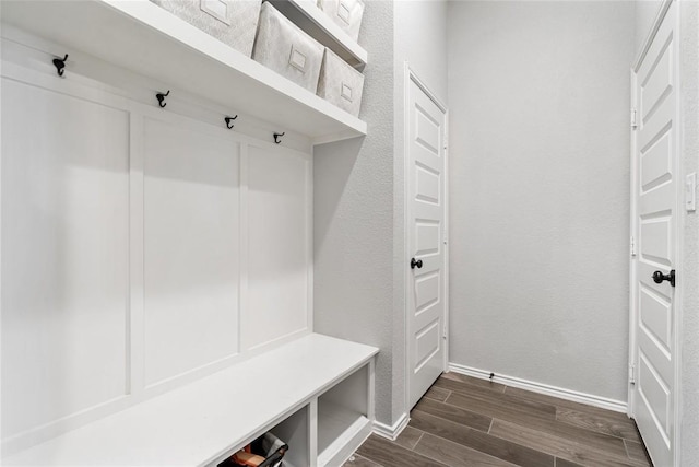 mudroom with a textured wall, wood finish floors, and baseboards