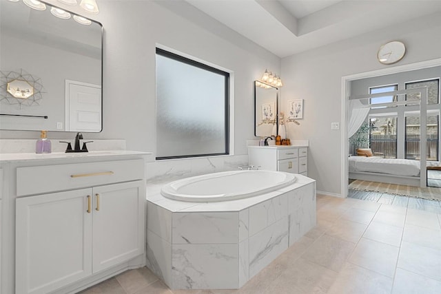 ensuite bathroom with a garden tub, connected bathroom, two vanities, and a sink