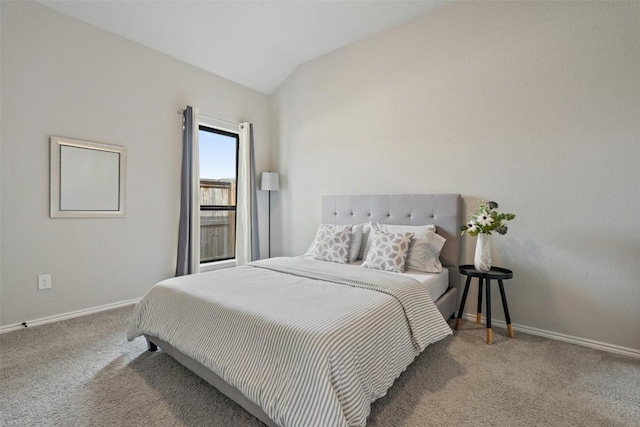 carpeted bedroom featuring lofted ceiling and baseboards