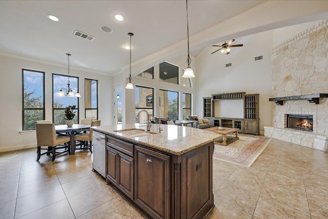 kitchen featuring visible vents, dishwasher, open floor plan, a fireplace, and a sink