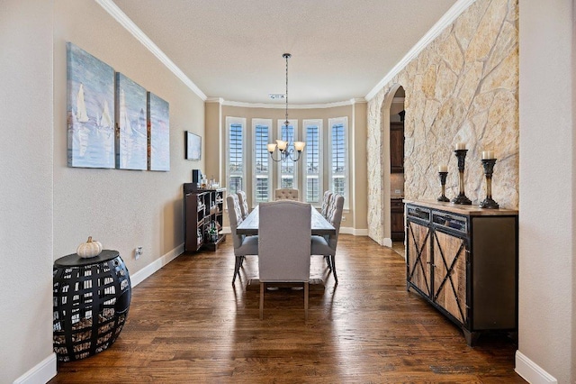 dining space with ornamental molding, an inviting chandelier, and dark wood-style floors