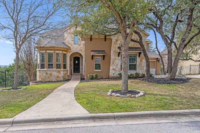 view of front facade featuring stone siding, fence, stucco siding, and a front yard