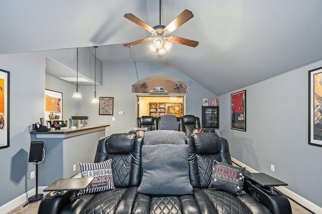 home theater featuring vaulted ceiling, ceiling fan, and baseboards