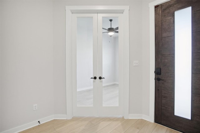 interior space featuring french doors, baseboards, and light wood finished floors