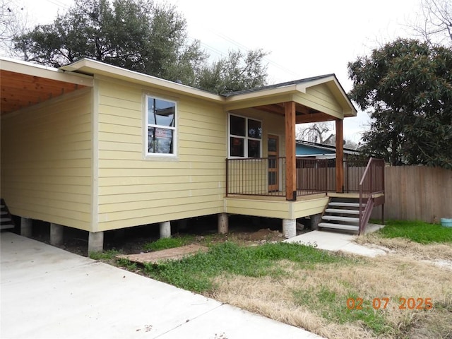 view of side of property with an attached carport and a deck