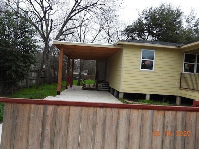 deck with entry steps, an attached carport, and fence private yard