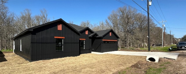 exterior space with board and batten siding, concrete driveway, and an attached garage