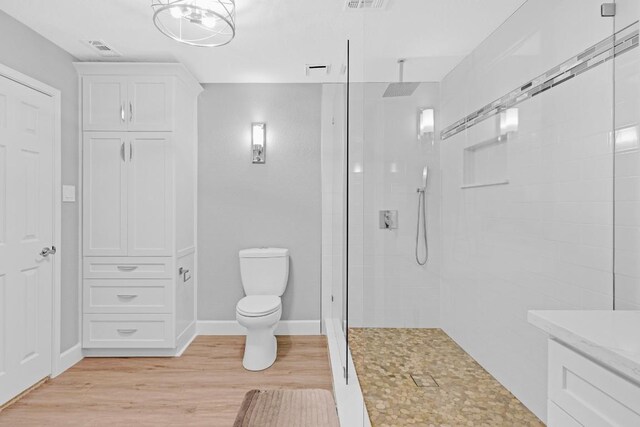 bathroom featuring toilet, visible vents, walk in shower, and wood finished floors