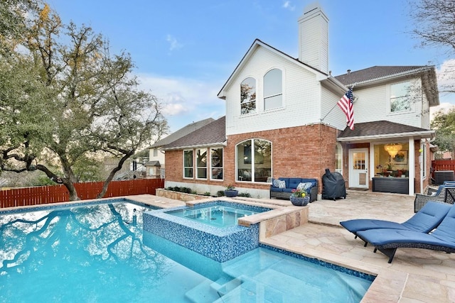 back of house featuring a patio, brick siding, a chimney, and fence