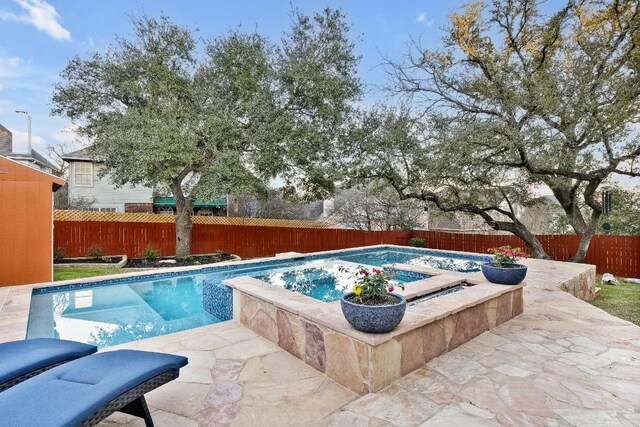 view of swimming pool with a fenced in pool, a patio area, a fenced backyard, and a hot tub