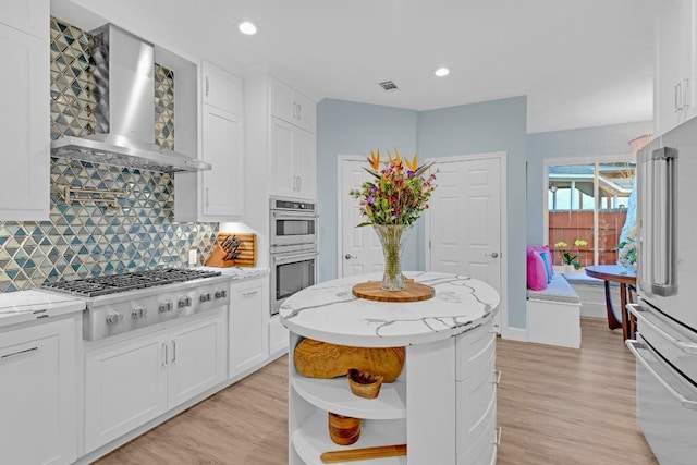 kitchen featuring open shelves, wall chimney range hood, white cabinetry, and stainless steel appliances