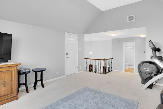 workout room with vaulted ceiling, baseboards, visible vents, and light colored carpet