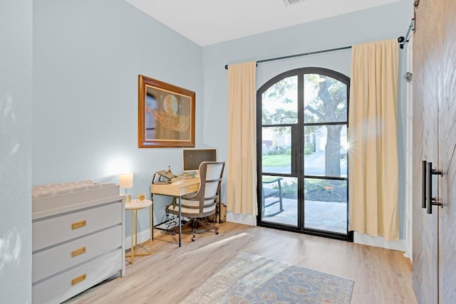 office space featuring a healthy amount of sunlight, visible vents, baseboards, and wood finished floors