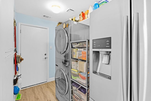 utility room featuring visible vents and stacked washer / drying machine