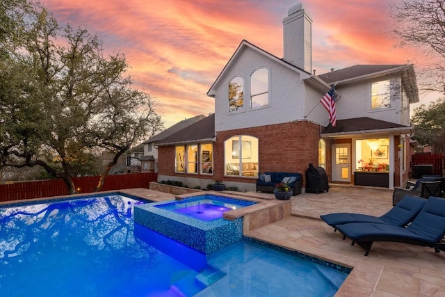 rear view of property featuring a patio area, fence, a chimney, and brick siding