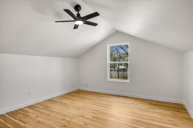 additional living space with lofted ceiling, light wood-type flooring, a ceiling fan, and baseboards