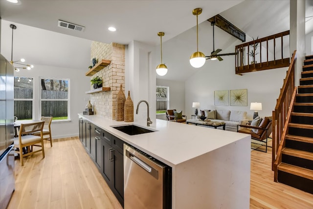 kitchen with light wood finished floors, open shelves, visible vents, stainless steel dishwasher, and a sink