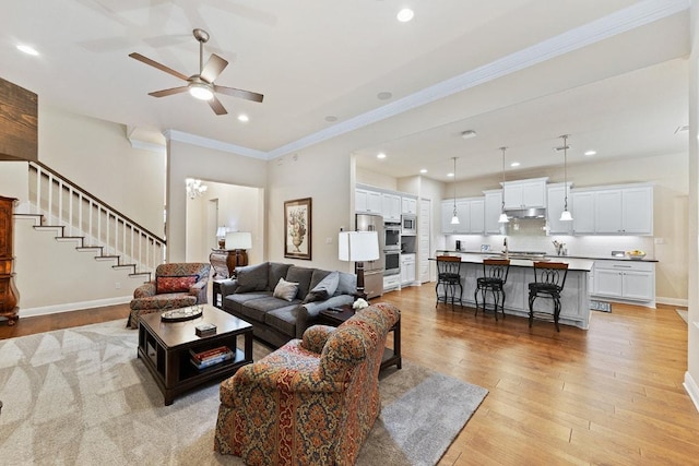 living room with recessed lighting, baseboards, light wood-style floors, stairway, and crown molding