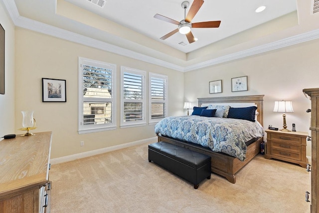 bedroom featuring light colored carpet, visible vents, baseboards, a raised ceiling, and crown molding