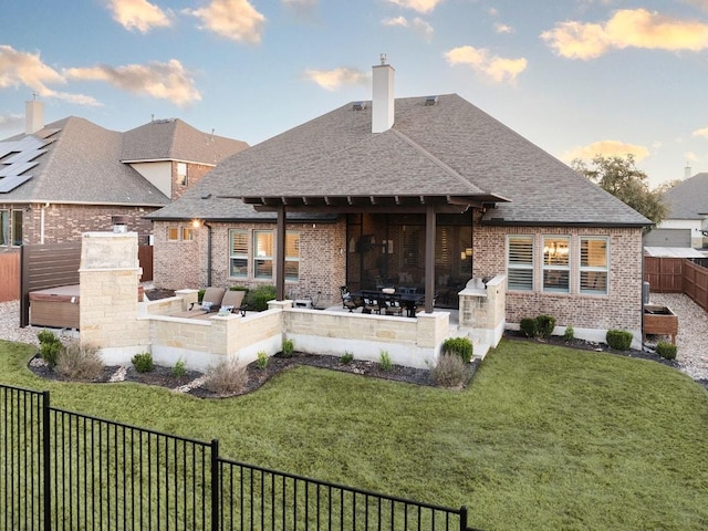 back of property featuring a patio, brick siding, an outdoor kitchen, and a fenced backyard