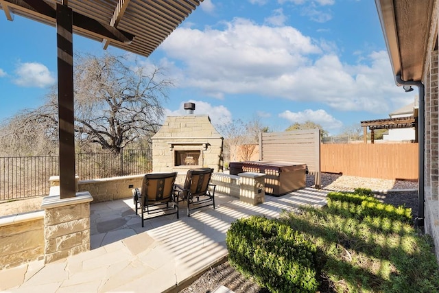 view of patio featuring an outdoor stone fireplace and a fenced backyard