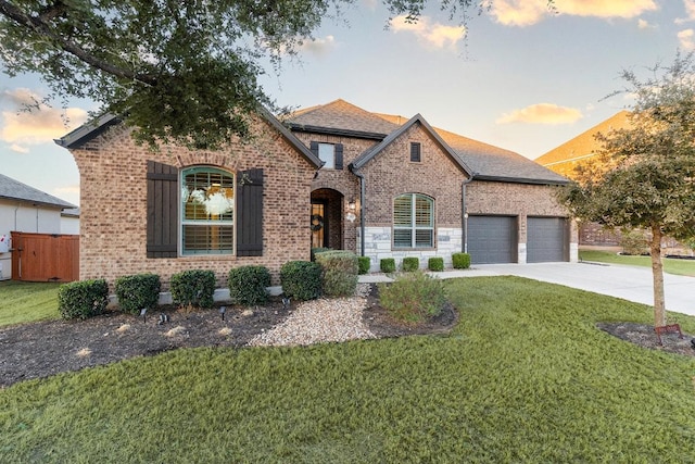 view of front of property with concrete driveway, brick siding, an attached garage, and a front yard