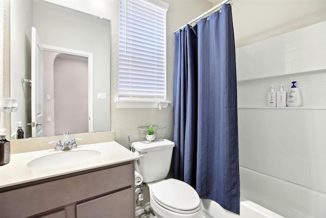 bathroom featuring toilet, shower / bath combination with curtain, and vanity