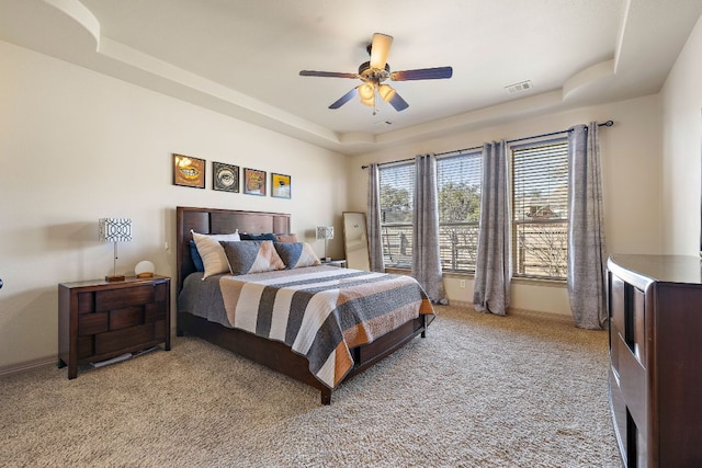 bedroom featuring ceiling fan, baseboards, a raised ceiling, and light colored carpet