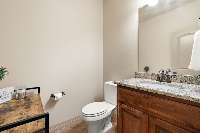 bathroom with toilet, baseboards, visible vents, and vanity