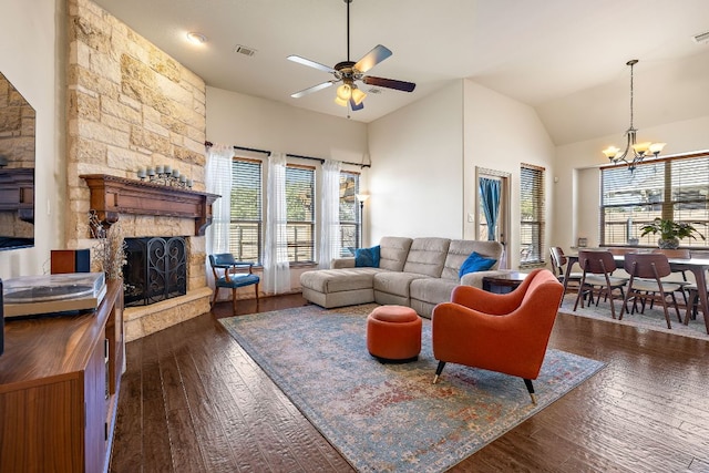 living room featuring visible vents, high vaulted ceiling, dark wood-style flooring, and a stone fireplace