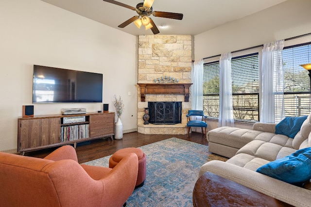 living room with ceiling fan, a fireplace, wood finished floors, and baseboards