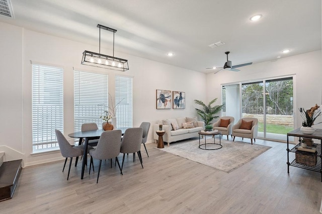 dining space with light wood-style flooring, visible vents, and a wealth of natural light