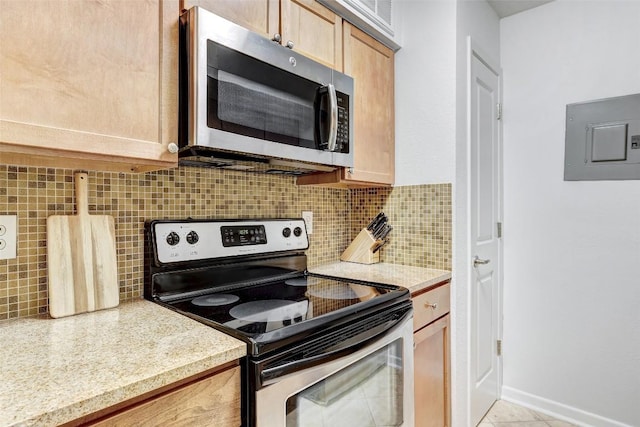 kitchen featuring light countertops, appliances with stainless steel finishes, electric panel, and decorative backsplash