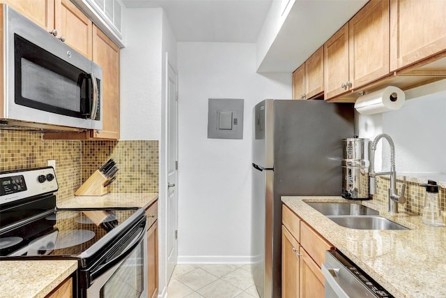 kitchen featuring light tile patterned floors, a sink, appliances with stainless steel finishes, electric panel, and tasteful backsplash