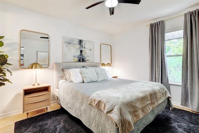 bedroom with ceiling fan, baseboards, and wood finished floors