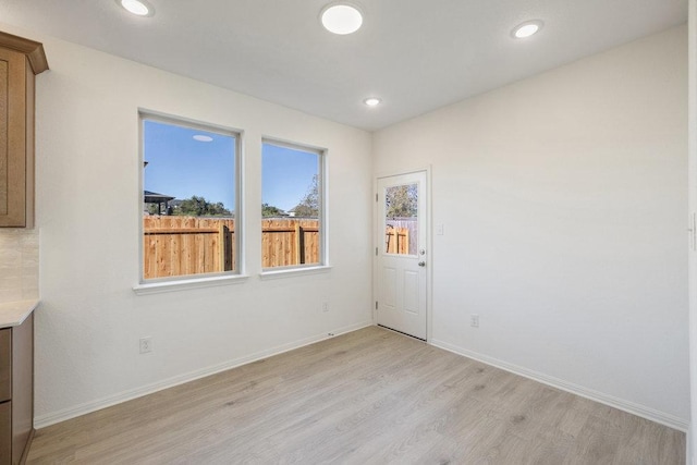 spare room with baseboards, light wood-type flooring, and recessed lighting