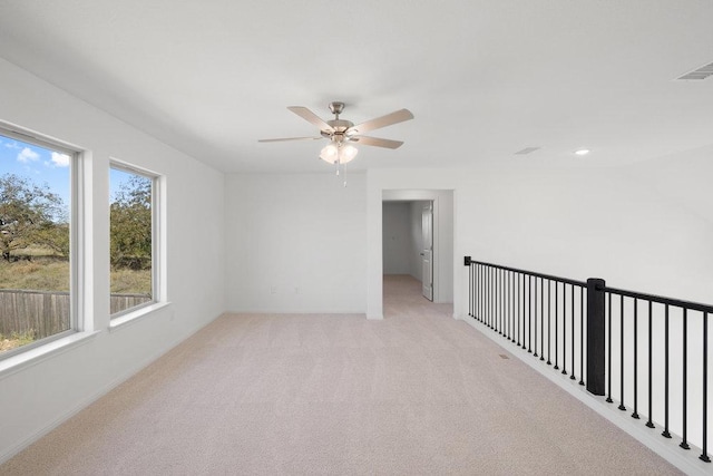 unfurnished room with a ceiling fan, light colored carpet, and visible vents