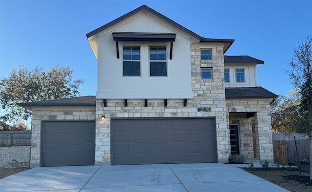 view of front of home featuring fence, concrete driveway, and stucco siding