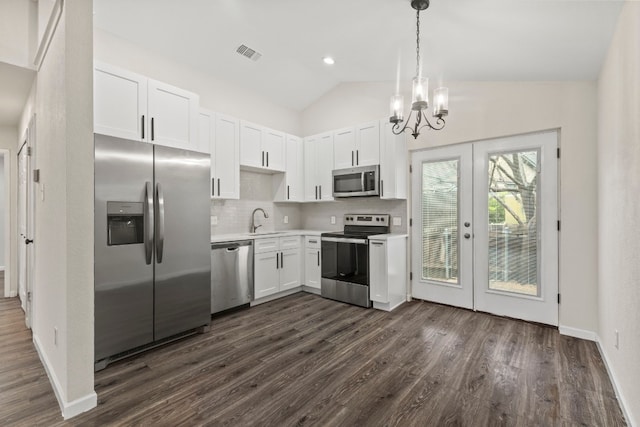 kitchen with visible vents, lofted ceiling, appliances with stainless steel finishes, light countertops, and a sink