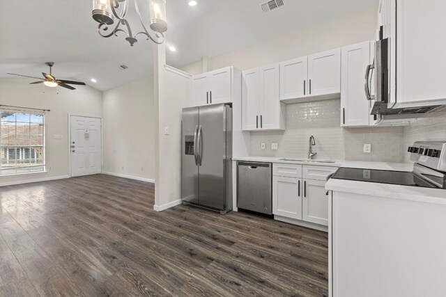 kitchen with stainless steel appliances, visible vents, white cabinetry, vaulted ceiling, and a sink