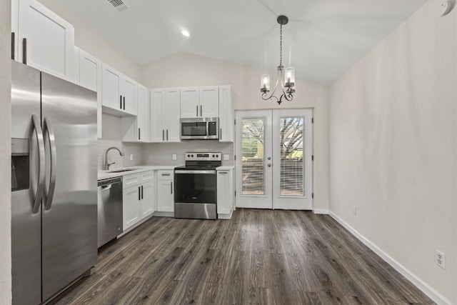 kitchen with lofted ceiling, white cabinetry, appliances with stainless steel finishes, and light countertops